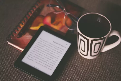Čtečka knih a šálek kávy